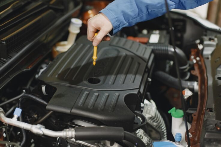 Mechanic performing a fluid check on a car engine at Union Auto Service in Union, NJ.